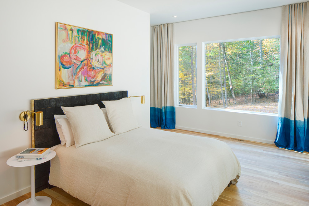 Ejemplo de dormitorio actual sin chimenea con paredes blancas, suelo de madera en tonos medios y suelo beige
