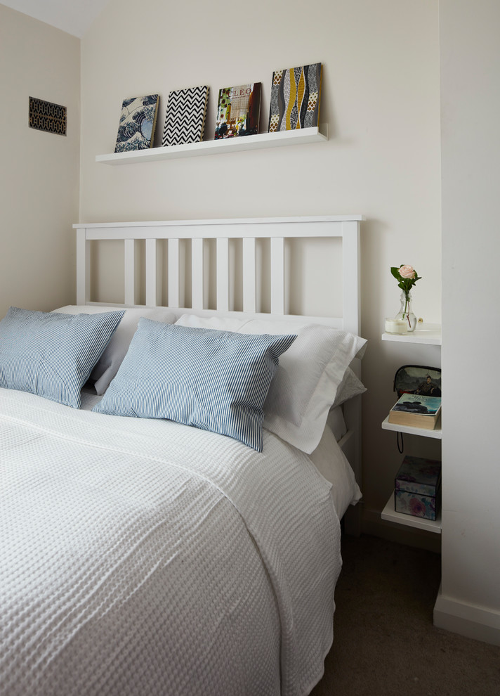 Kleines Modernes Schlafzimmer mit weißer Wandfarbe, Teppichboden, Eckkamin, Kaminumrandung aus Metall und beigem Boden in Dublin