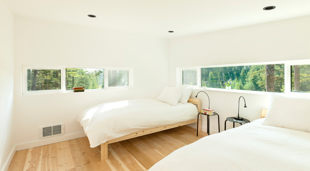 Imagen de dormitorio tipo loft rústico pequeño con paredes blancas y suelo de madera clara