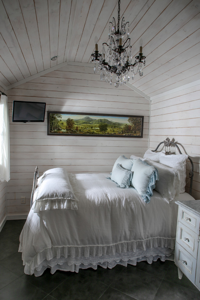 Kleines Shabby-Chic Hauptschlafzimmer mit weißer Wandfarbe, Porzellan-Bodenfliesen und Kaminumrandung aus Stein in Charlotte