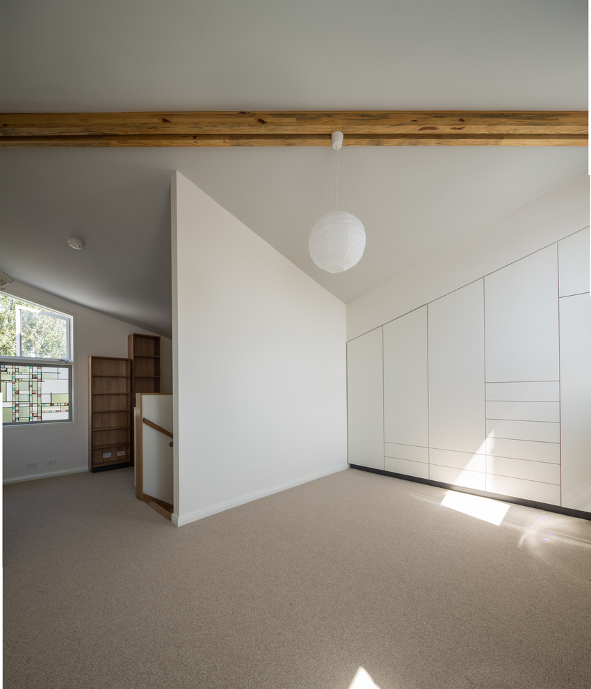 Imagen de dormitorio tipo loft contemporáneo pequeño con paredes blancas y moqueta