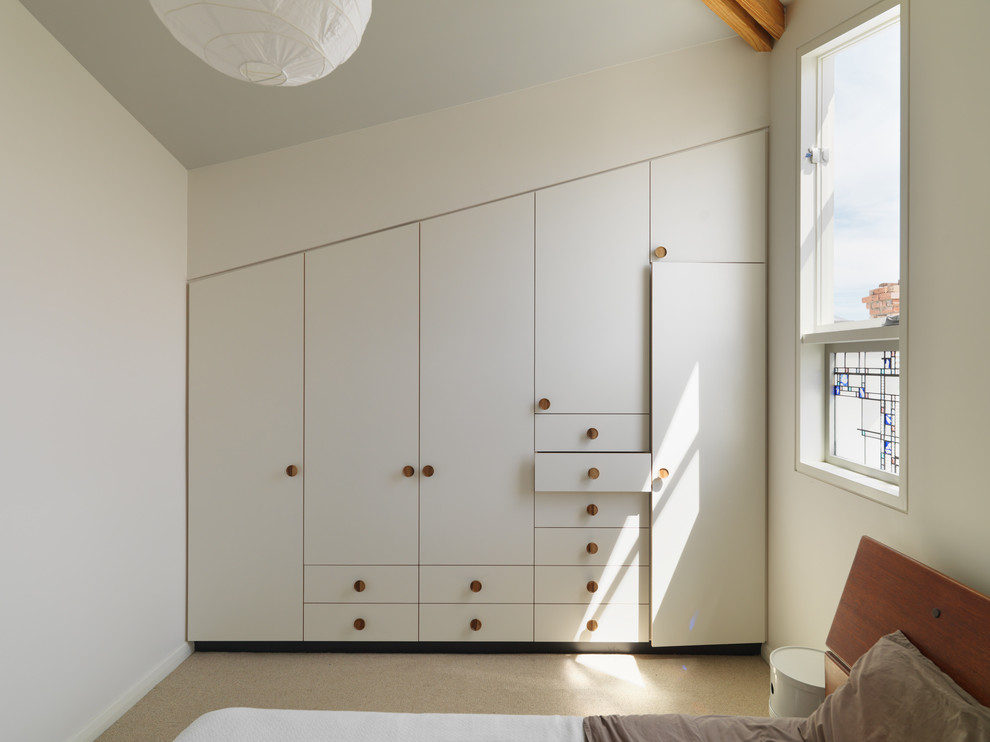 Idee per una piccola camera da letto stile loft design con pareti bianche e moquette