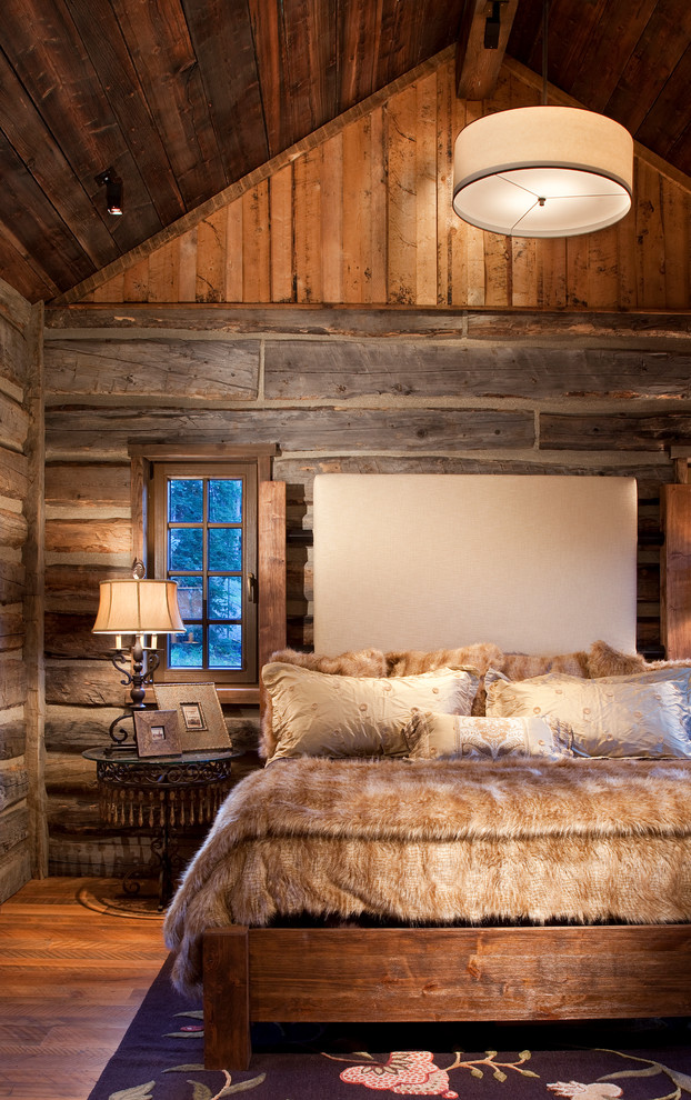 Immagine di una camera matrimoniale stile rurale con pavimento in legno massello medio