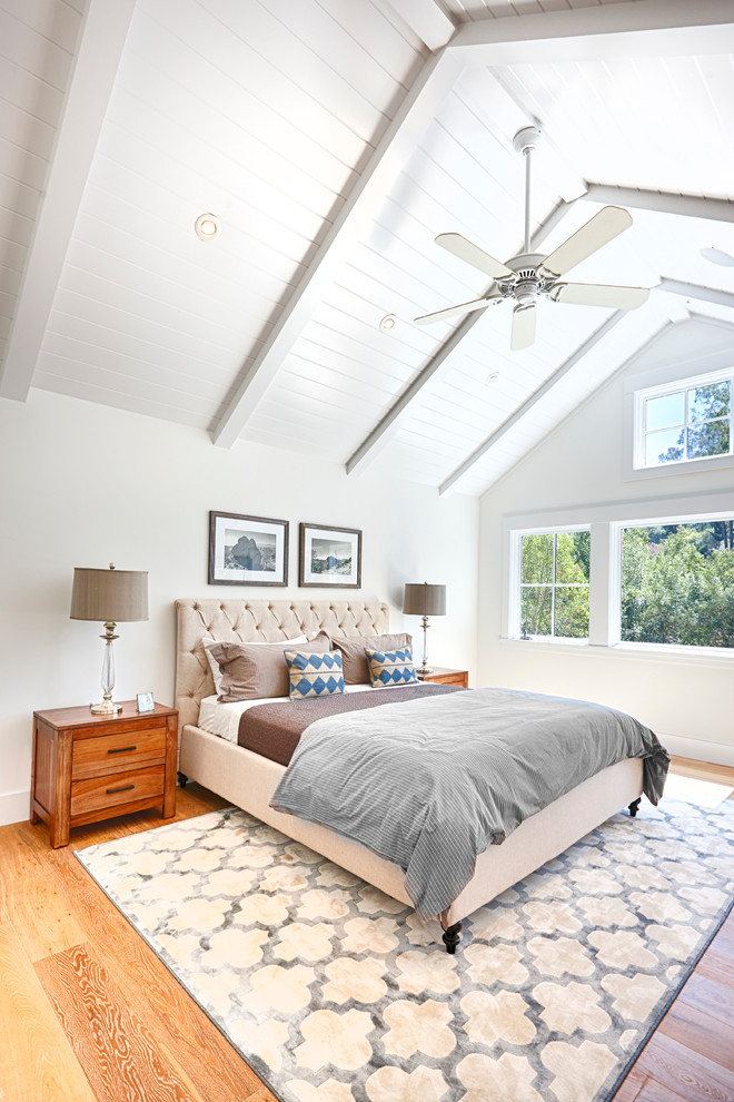 Large rural bedroom in San Francisco with white walls and medium hardwood flooring.