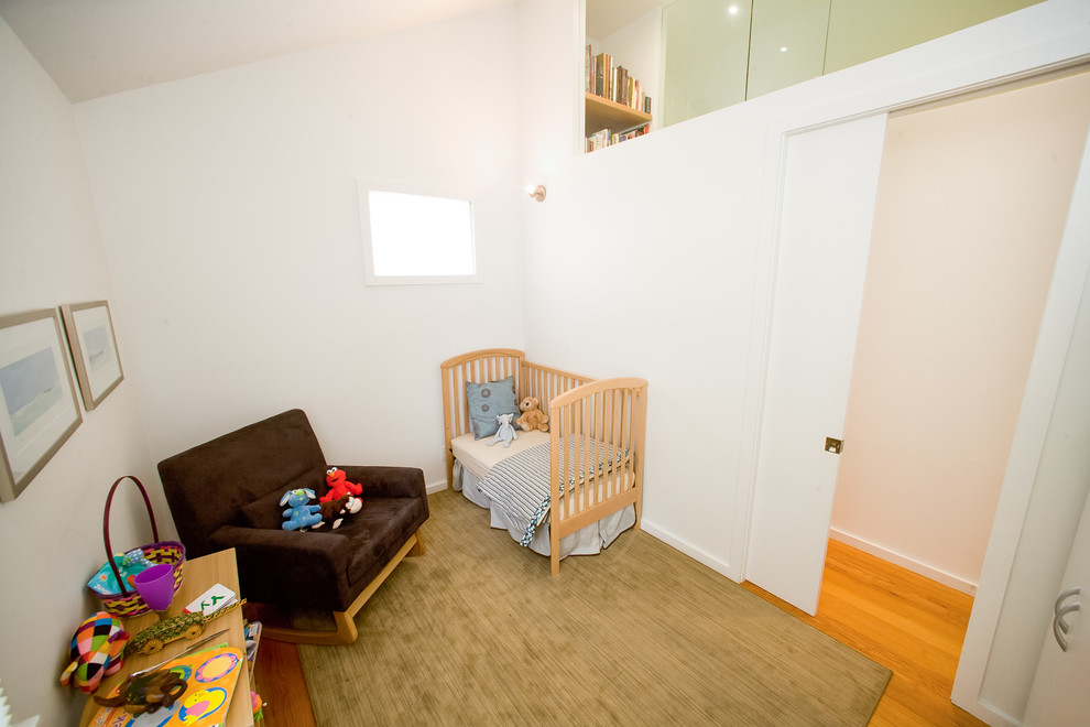 Cette photo montre une petite chambre moderne avec un mur blanc et parquet clair.