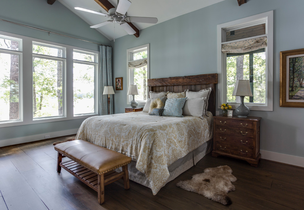 Foto på ett rustikt sovrum, med blå väggar, mörkt trägolv och brunt golv