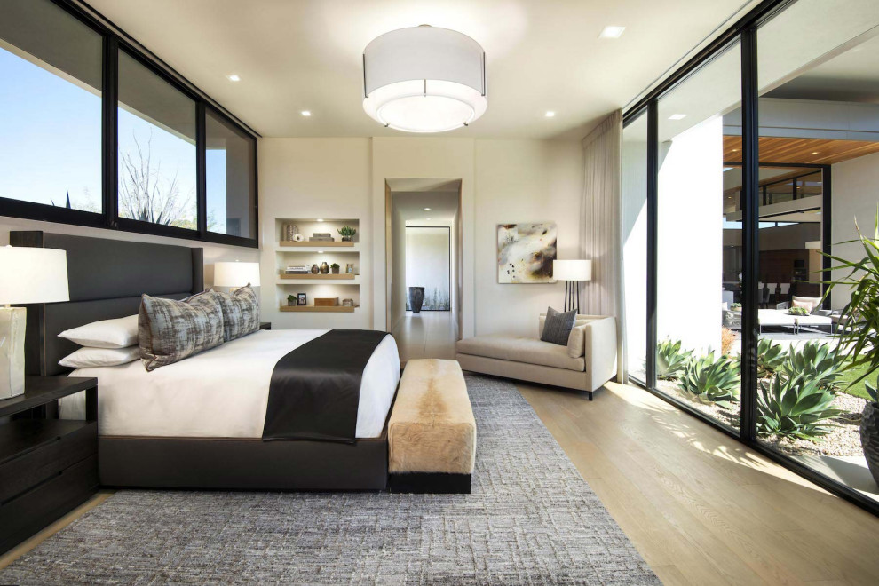 Geräumiges Modernes Hauptschlafzimmer mit weißer Wandfarbe, braunem Holzboden, Tunnelkamin und Kaminumrandung aus Metall in Phoenix