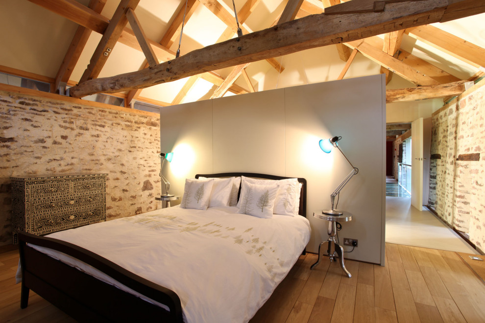 Ejemplo de dormitorio principal contemporáneo grande con paredes beige, suelo de madera clara, suelo beige y vigas vistas
