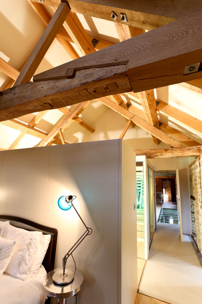 Großes Modernes Hauptschlafzimmer mit beiger Wandfarbe, hellem Holzboden, beigem Boden und freigelegten Dachbalken in Gloucestershire