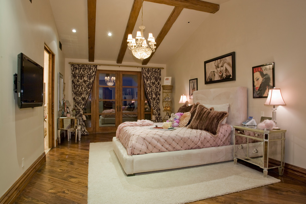 Ejemplo de dormitorio principal clásico extra grande con paredes beige, suelo de madera oscura, chimenea de doble cara, marco de chimenea de piedra y suelo marrón
