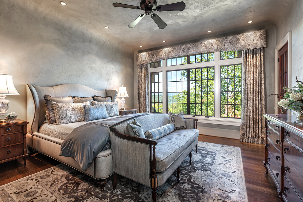 Imagen de dormitorio principal clásico grande con paredes grises, suelo de madera en tonos medios y suelo marrón