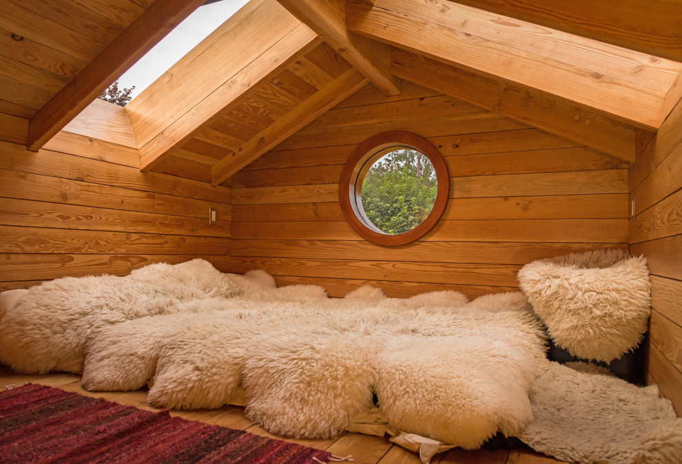 Ispirazione per una piccola camera da letto stile loft stile americano con pareti marroni, pavimento in legno massello medio e pavimento marrone