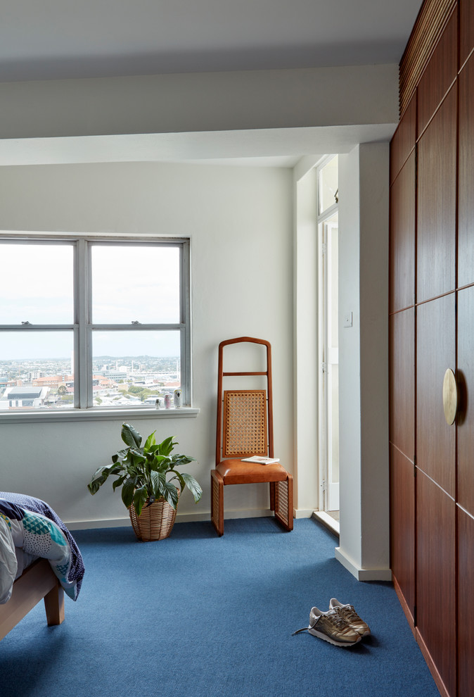 Immagine di una camera matrimoniale minimalista di medie dimensioni con pareti bianche, moquette e pavimento blu
