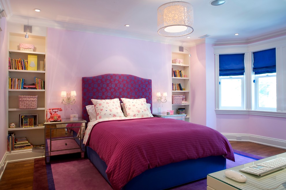 Klassisk inredning av ett mellanstort sovrum, med rosa väggar, mellanmörkt trägolv och brunt golv