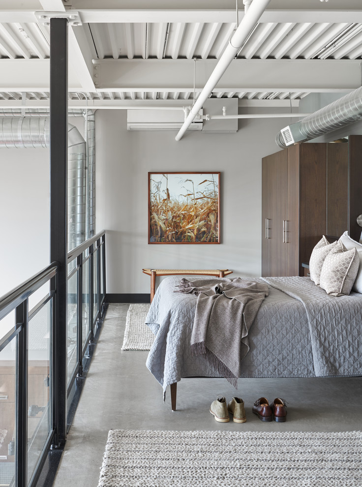 トロントにある中くらいなインダストリアルスタイルのおしゃれなロフト寝室 (コンクリートの床、グレーの床、グレーの壁) のレイアウト