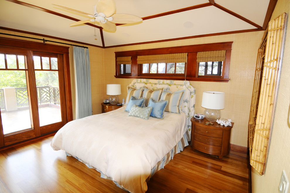 Ejemplo de dormitorio principal tropical de tamaño medio con paredes beige, suelo de madera clara, suelo marrón, todas las chimeneas y marco de chimenea de madera