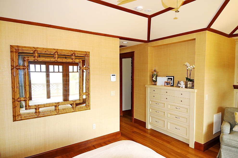 На фото: хозяйская спальня среднего размера в морском стиле с бежевыми стенами, светлым паркетным полом, стандартным камином, фасадом камина из дерева и коричневым полом