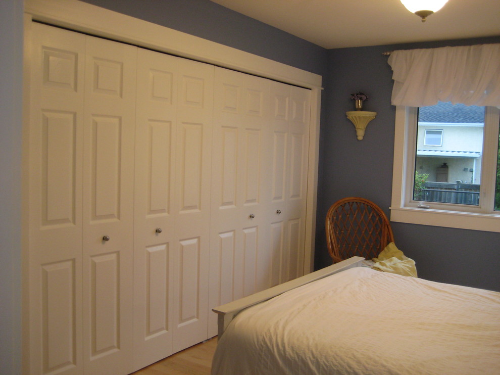 Photo of a medium sized bohemian master bedroom in Vancouver with blue walls and light hardwood flooring.