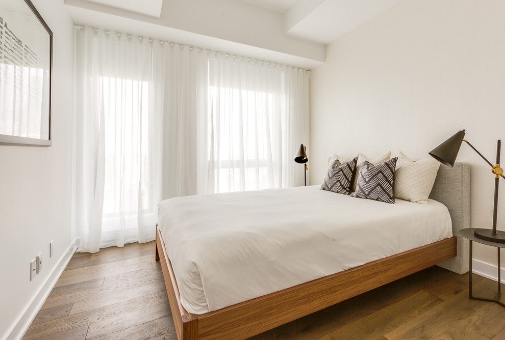 Esempio di una piccola camera degli ospiti chic con pareti bianche e pavimento in legno massello medio