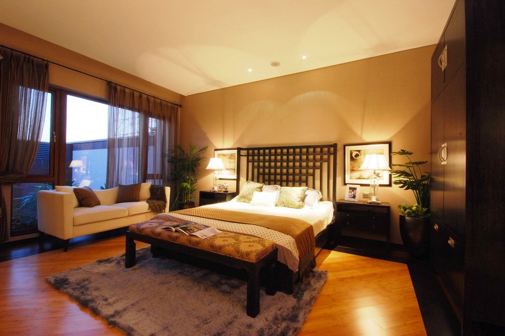 Modelo de dormitorio principal clásico renovado de tamaño medio sin chimenea con paredes beige y suelo de madera clara