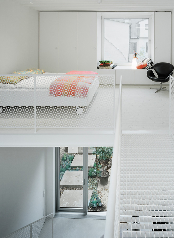 Großes Modernes Hauptschlafzimmer mit weißer Wandfarbe und Betonboden in Malmö