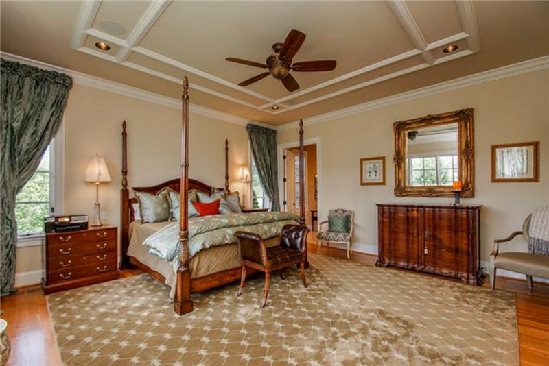 Diseño de dormitorio principal clásico grande con paredes beige y suelo de madera en tonos medios