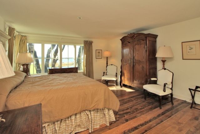 Imagen de dormitorio principal tradicional grande con paredes blancas y suelo de madera oscura