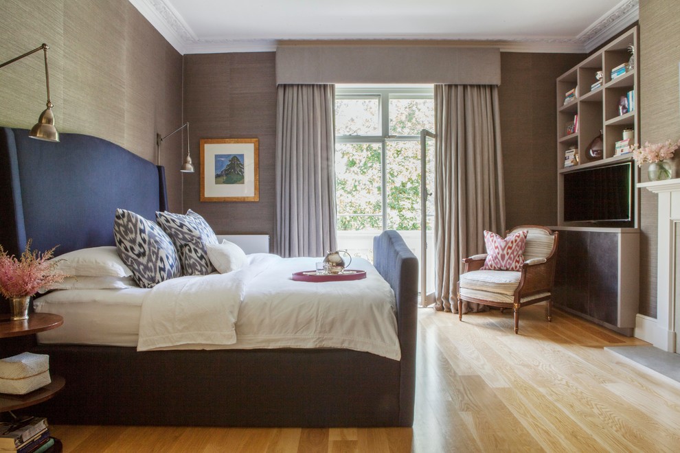 Imagen de dormitorio televisión tradicional con paredes beige y suelo de madera clara