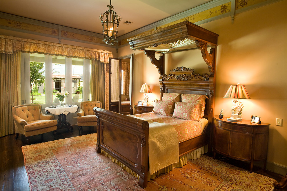 Foto di una camera da letto vittoriana con pareti beige e parquet scuro