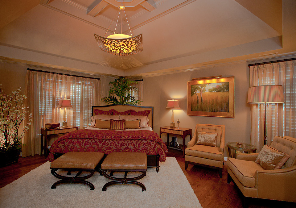 Example of a large classic master medium tone wood floor bedroom design in Raleigh with beige walls and no fireplace