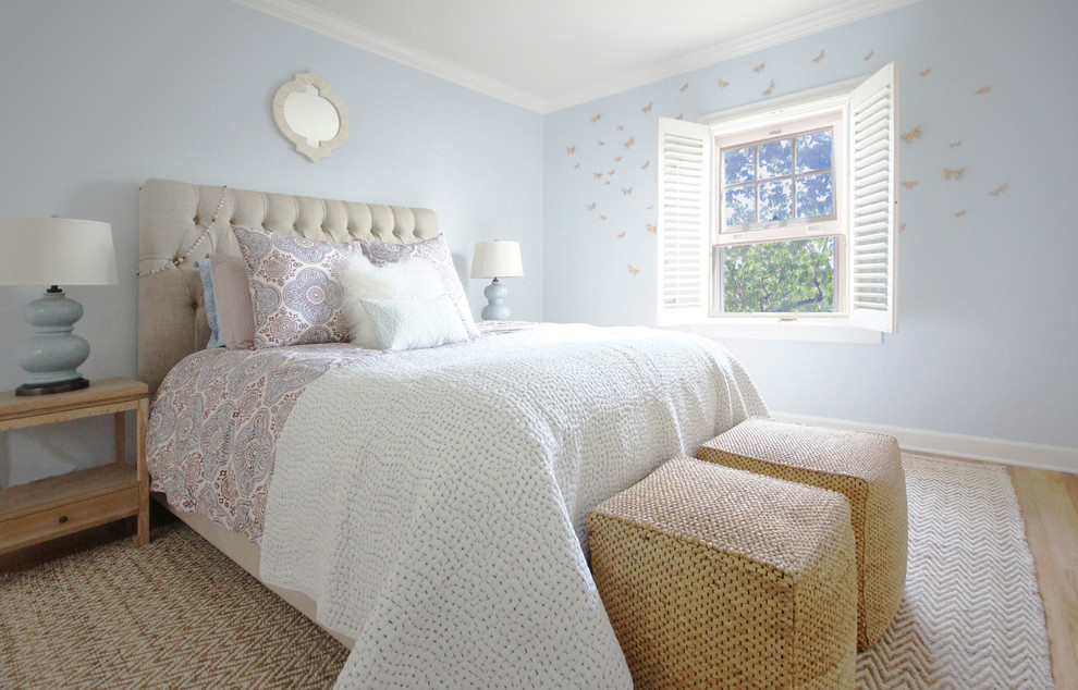 Ejemplo de dormitorio principal clásico grande sin chimenea con paredes azules, suelo de madera clara y suelo beige