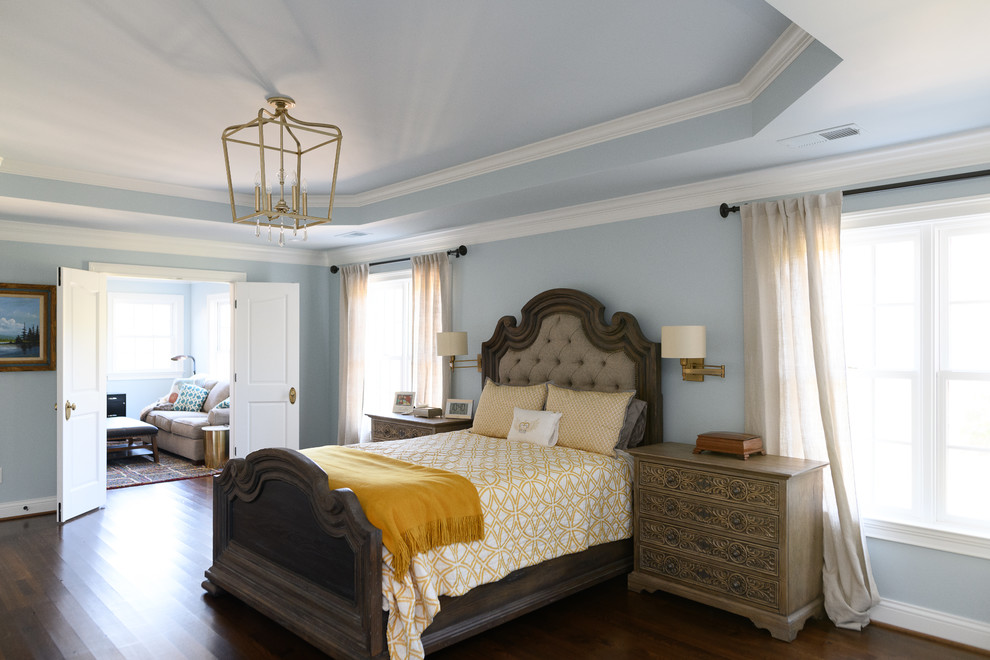 Immagine di una camera da letto chic con pareti blu, parquet scuro e pavimento marrone