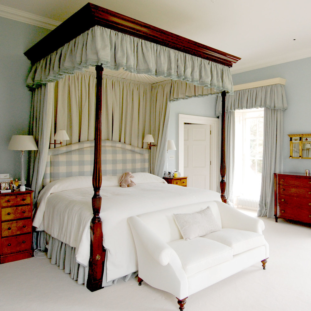 Design ideas for a traditional master bedroom in London with blue walls and carpet.