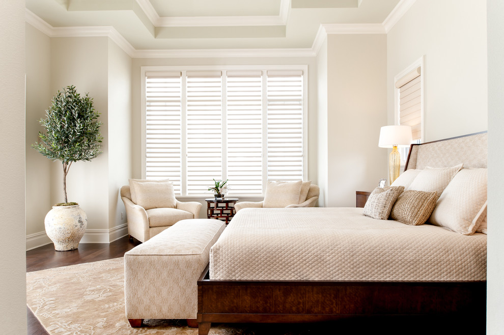 Traditional bedroom in Orlando with beige walls and dark hardwood flooring.