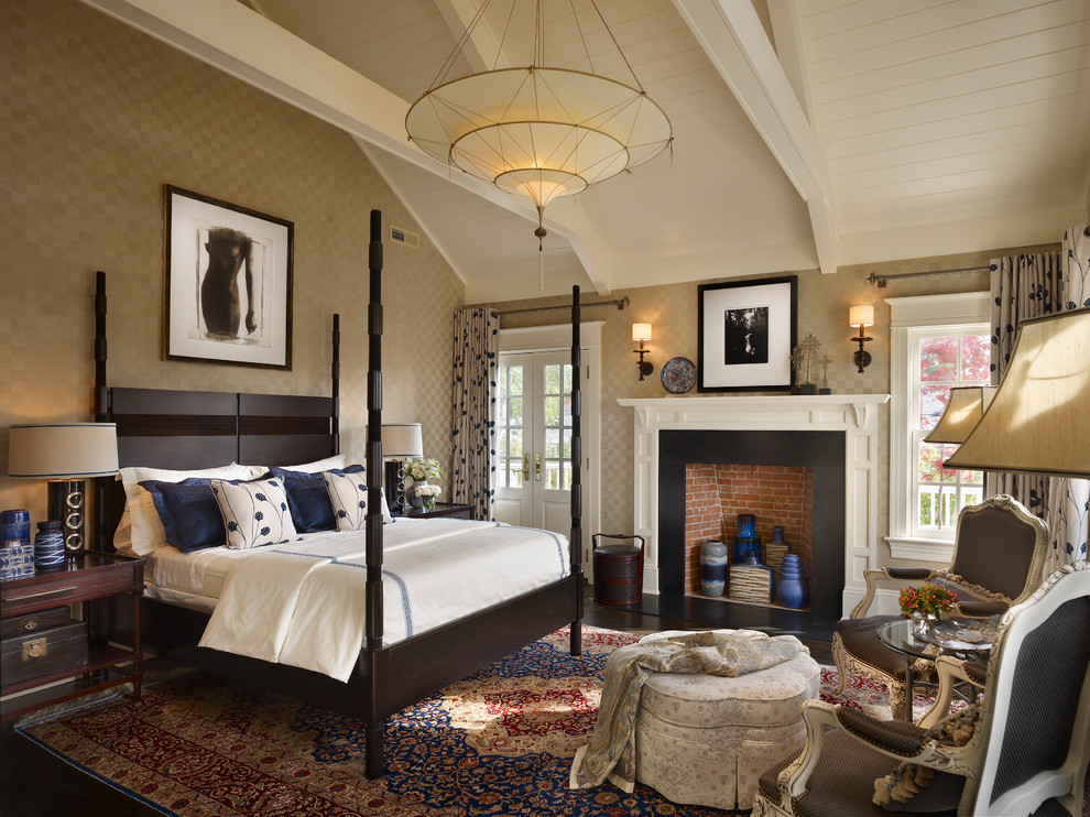 Elegant master bedroom photo in New York with beige walls and a standard fireplace