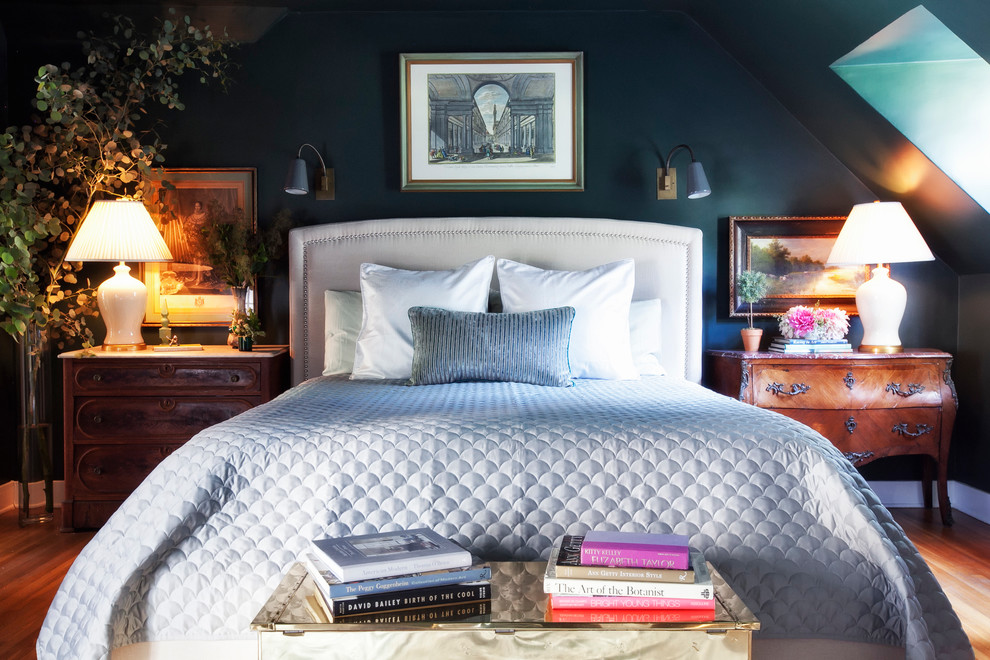 Example of a classic medium tone wood floor bedroom design in Los Angeles with black walls and no fireplace