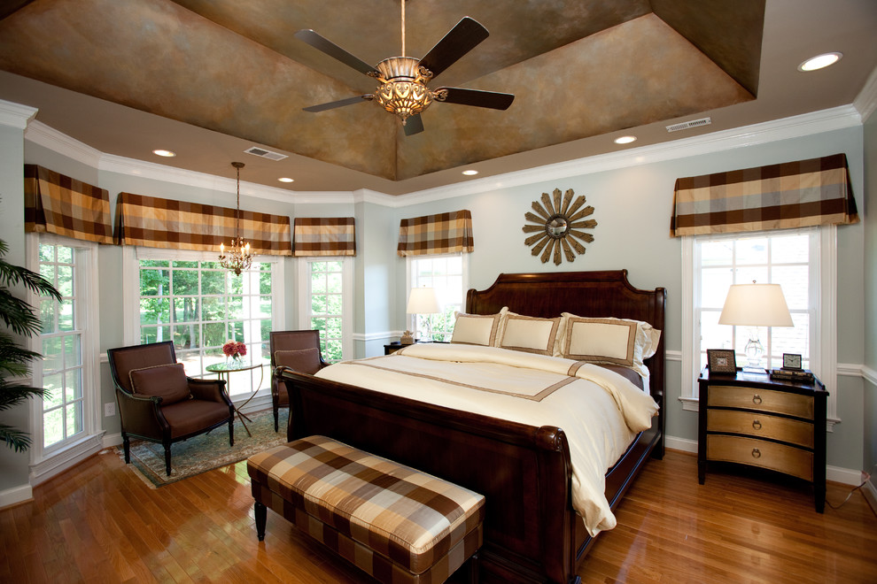 Elegant medium tone wood floor bedroom photo in Charlotte with gray walls