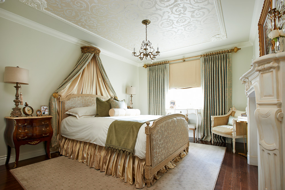 Пример оригинального дизайна: хозяйская спальня в классическом стиле с зелеными стенами, темным паркетным полом и стандартным камином