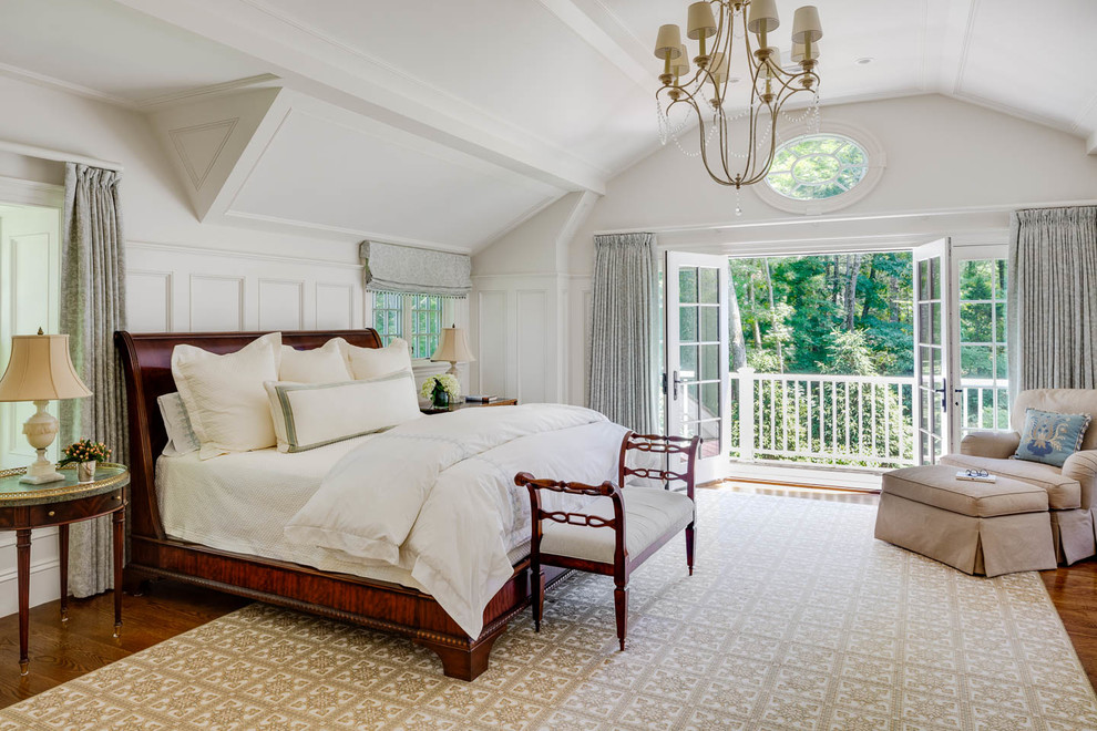 Imagen de dormitorio principal clásico de tamaño medio sin chimenea con paredes blancas y suelo de madera en tonos medios