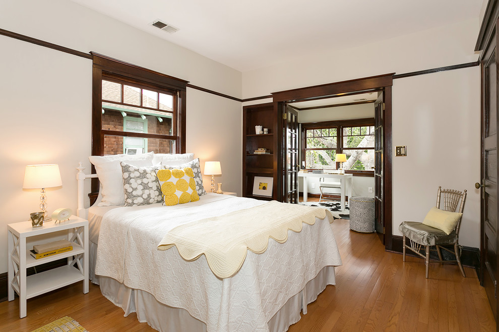 Foto de habitación de invitados tradicional de tamaño medio con paredes blancas, suelo de madera en tonos medios, chimenea lineal y suelo marrón