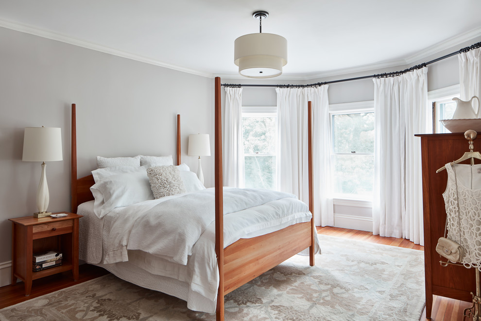 Foto de dormitorio principal tradicional de tamaño medio sin chimenea con paredes grises y suelo de madera en tonos medios