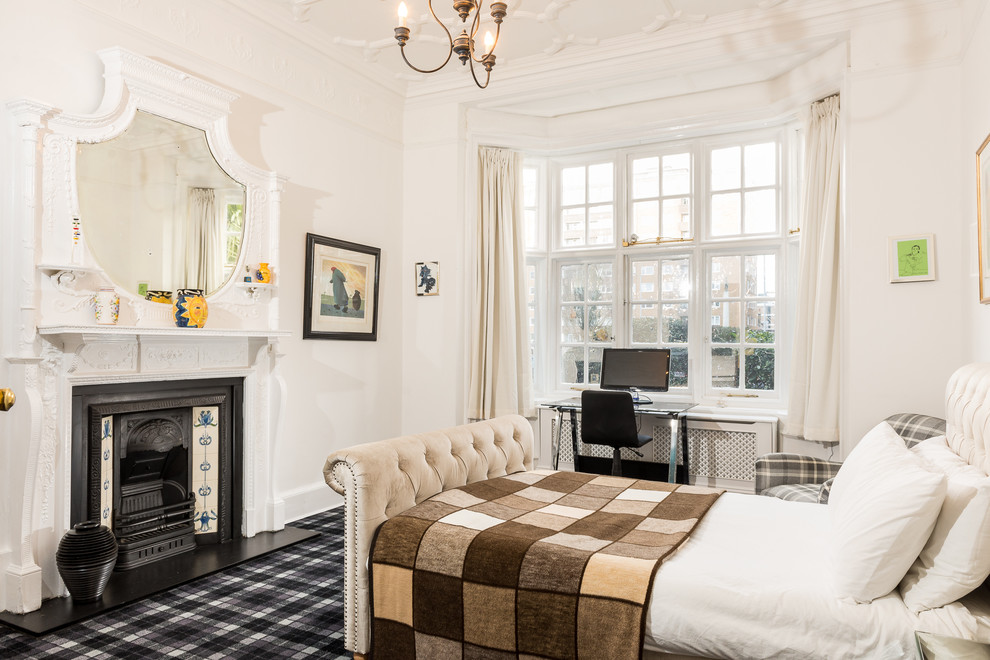 Klassisches Schlafzimmer mit weißer Wandfarbe, Teppichboden und Kamin in Sussex