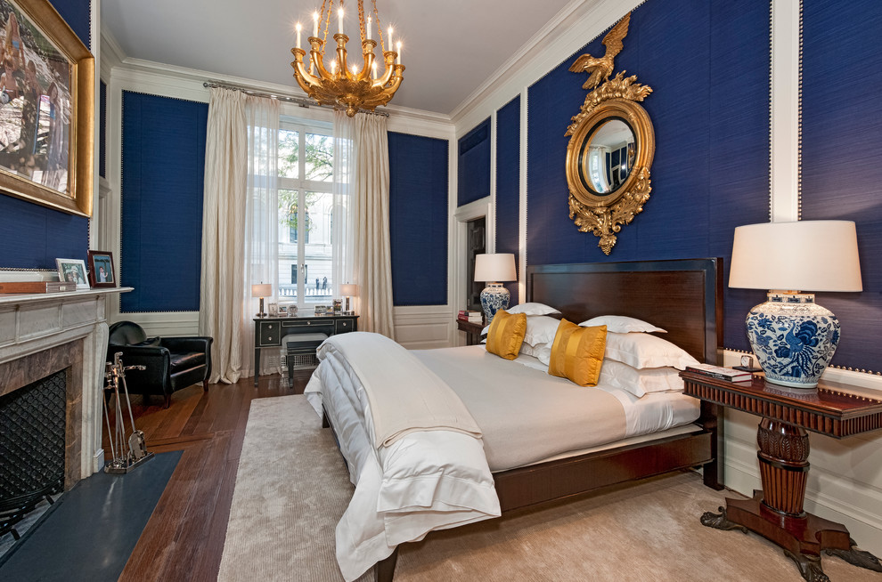 Идея дизайна: спальня в классическом стиле с синими стенами, темным паркетным полом и стандартным камином