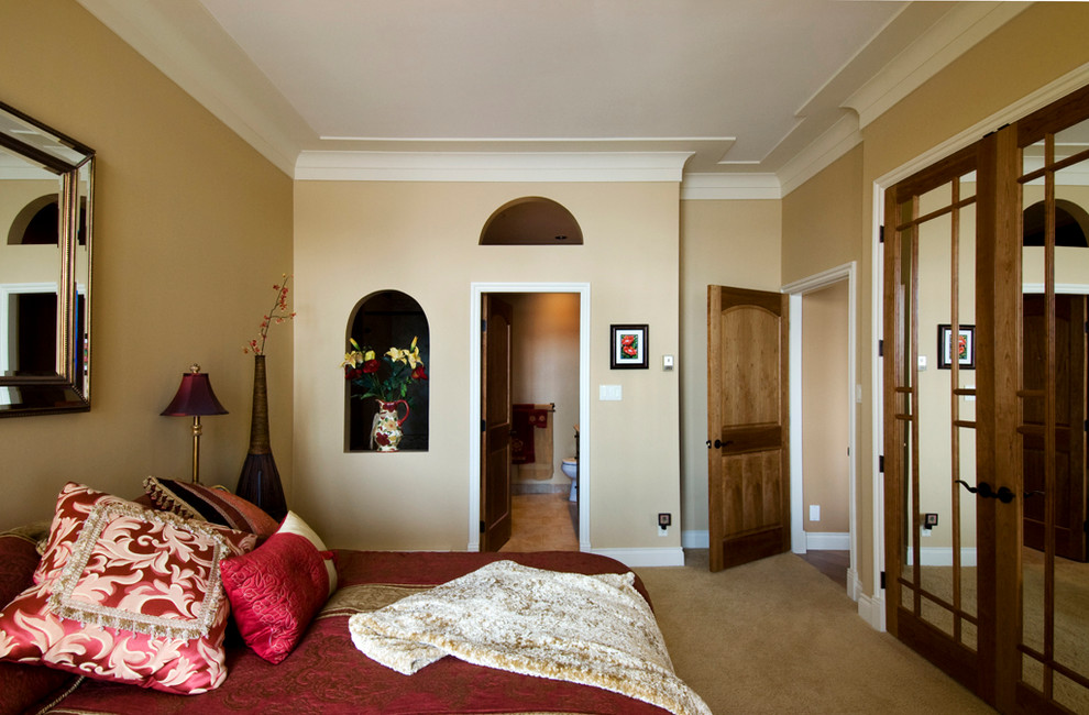 На фото: большая хозяйская спальня в классическом стиле с желтыми стенами и ковровым покрытием без камина