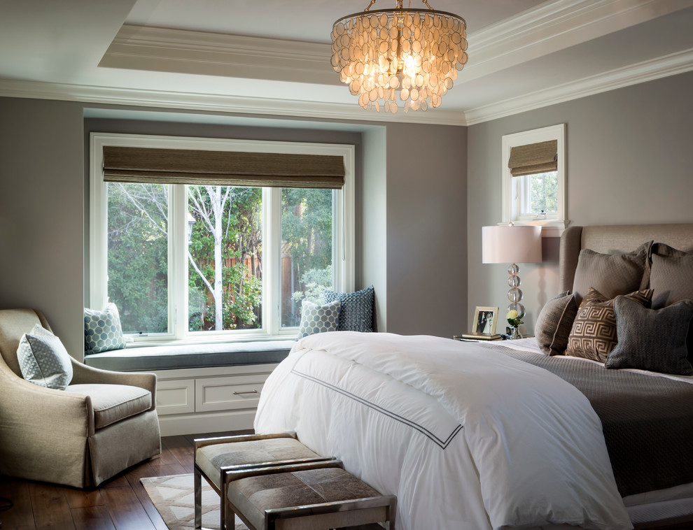 Foto de dormitorio principal clásico de tamaño medio con paredes grises, suelo de madera en tonos medios y marco de chimenea de piedra