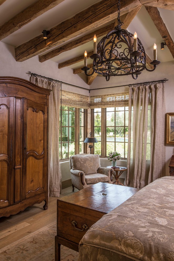 Ejemplo de dormitorio principal rústico grande con paredes beige y suelo de madera clara