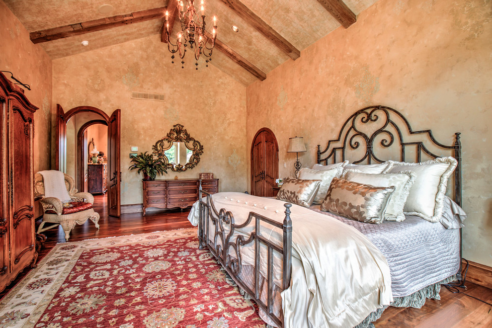 Imagen de dormitorio principal mediterráneo de tamaño medio sin chimenea con paredes beige y suelo de madera en tonos medios