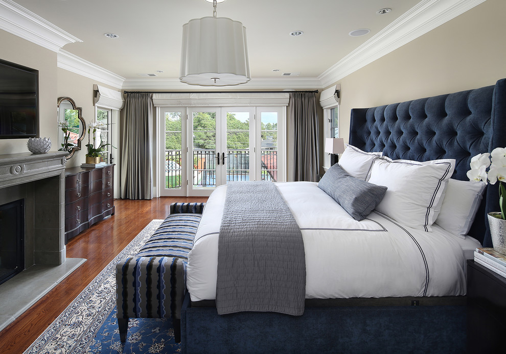 Inspiration for a traditional master bedroom in San Francisco with beige walls, medium hardwood flooring, a standard fireplace, a stone fireplace surround and brown floors.
