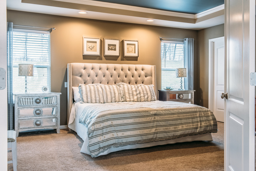 This is an example of a large classic master bedroom in Detroit with beige walls, carpet and beige floors.