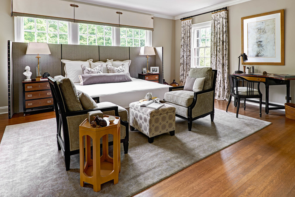 Ejemplo de dormitorio clásico renovado con paredes beige, suelo de madera en tonos medios y con escritorio